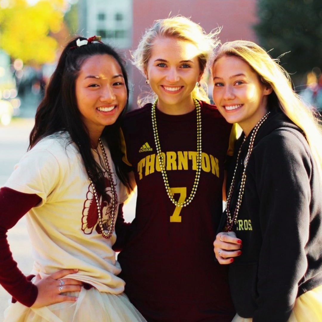 3 happy high school girls smiling with school spirit