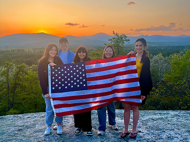 Friends on cliff with American flag